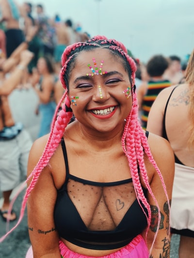 一个穿着黑色背心，戴着红白围巾，面带微笑的女人